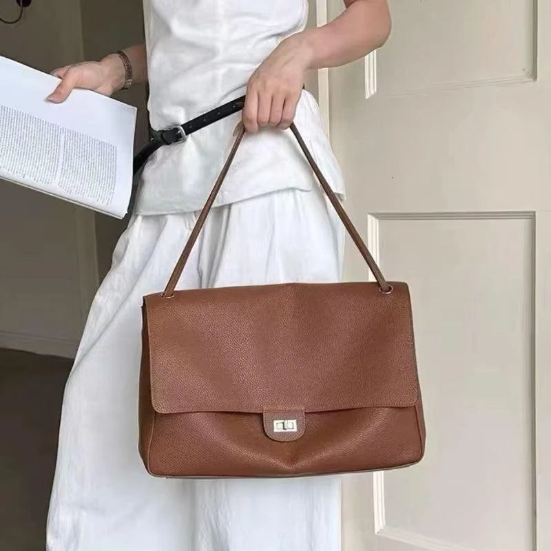 Bolsa Turim caramelo usada no ombro com vestido branco | Vivièn