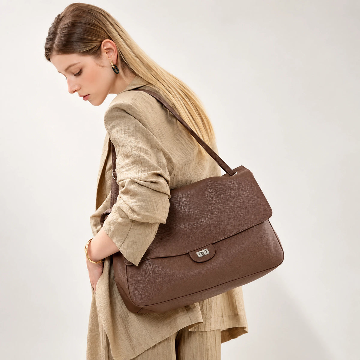 Bolsa Turim marrom usada no ombro com look em linho | Vivièn