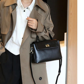 Bolsa Victoire preta usada na mão com look neutro | Vivièn