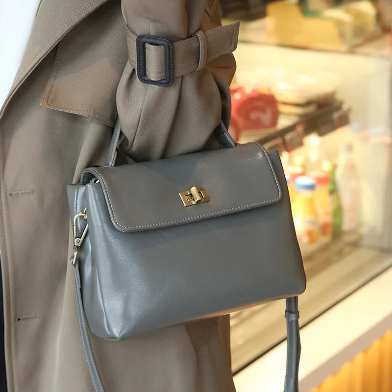 Bolsa Victoire taupe usada na mão com trench coat | Vivièn