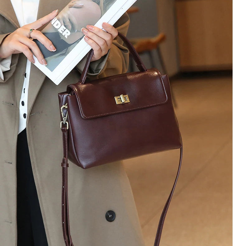 Bolsa Victoire vinho usada na mão com casaco bege | Vivièn